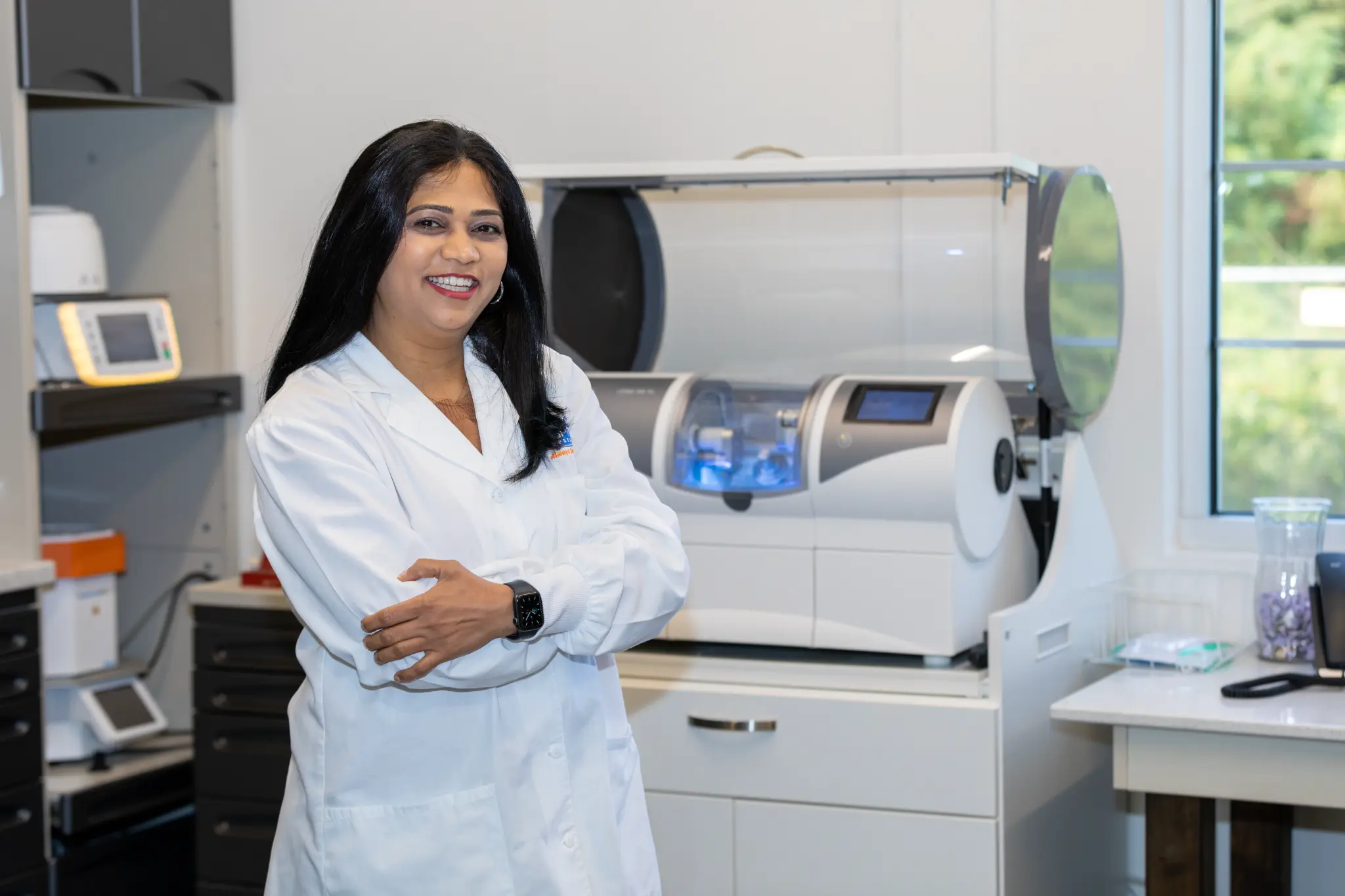 Dr. Vaibhavi Patel beside in-office same-day crown technology at VSP Dental